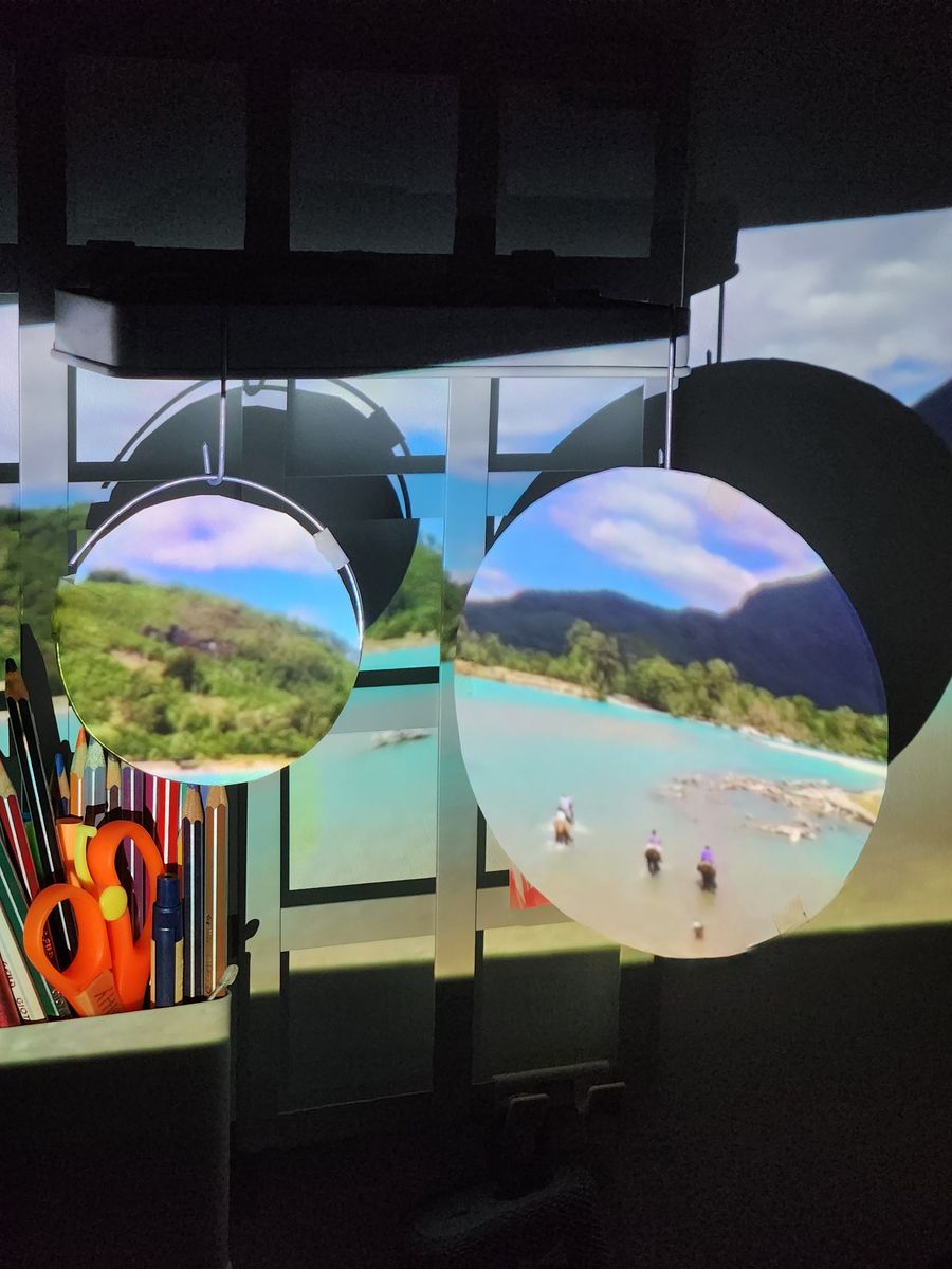 Two hanging circles with a lake landscape projected on them