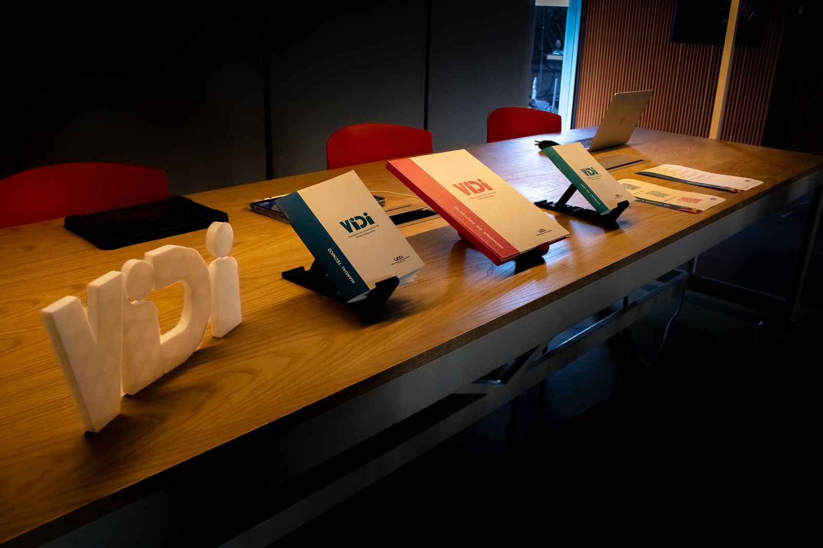 Wooden table with the VIDI manuals and memoria and a 3D-printed VIDI logo