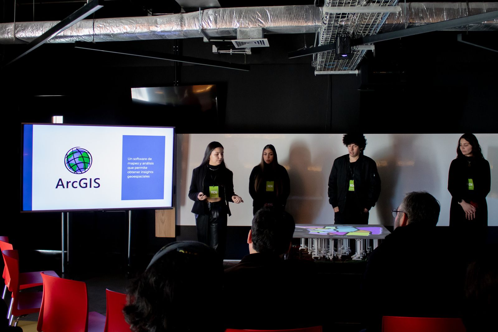 Brigade presenting next to the interface screen, with the audience seated in front