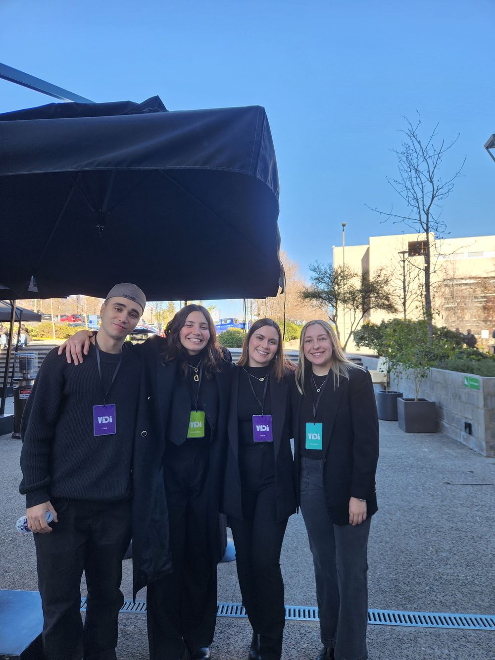 Four members of the group smiling outdoors after the presentation